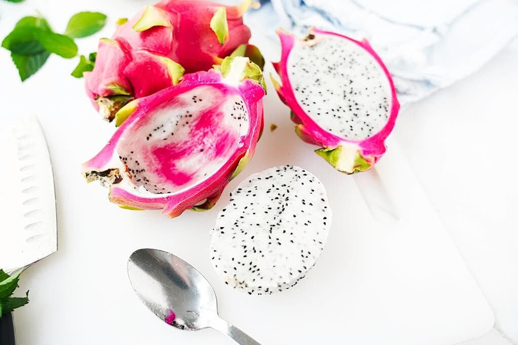 Dragon fruit flesh scooped out with spoon