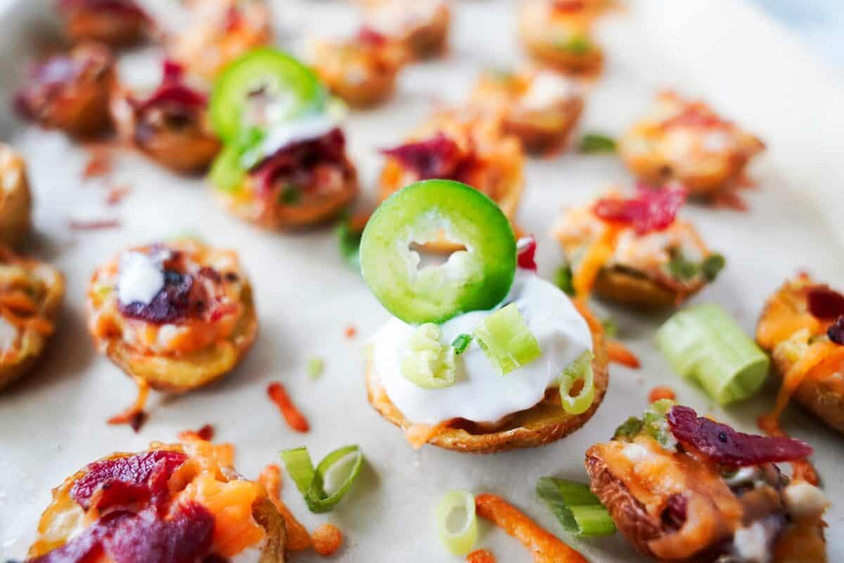 Jalapeño popper poato skins on a parchment line baking sheet