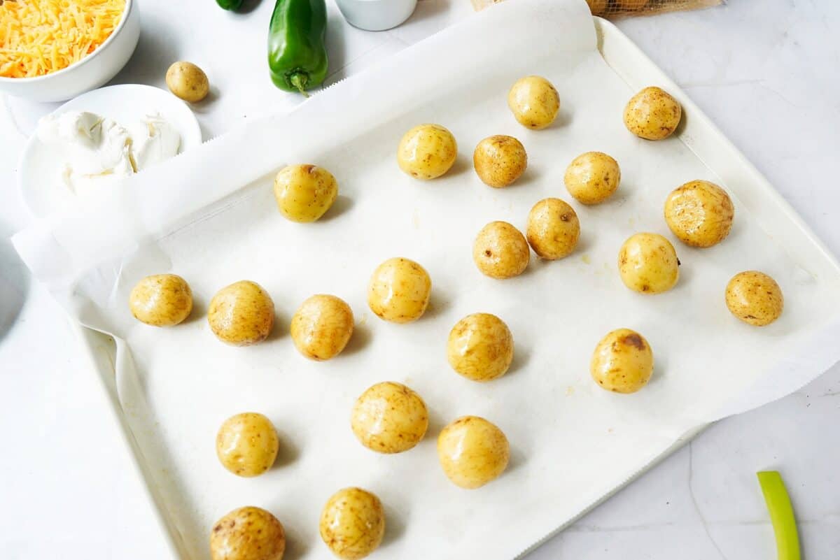 Poked smalls potatoes on a parchment lined baking sheet