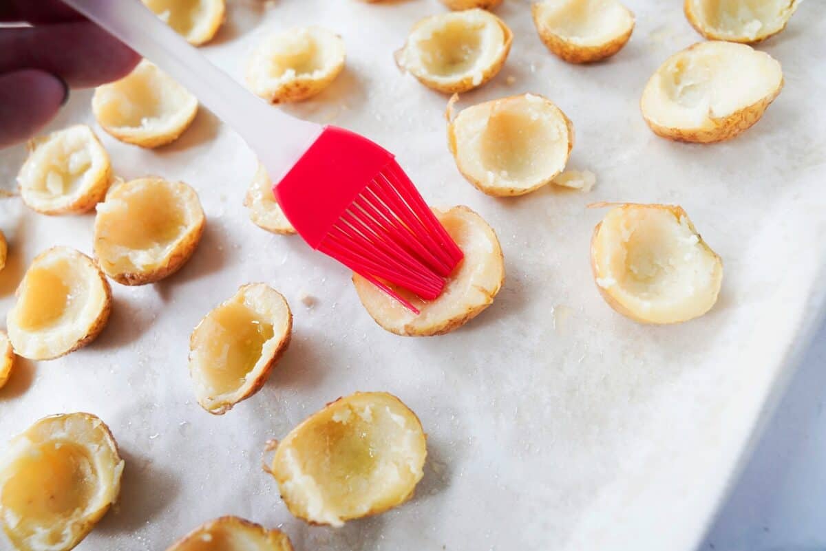 Brush the hollowed out potatoes with olive oil on a parchmanet lined baking sheet.